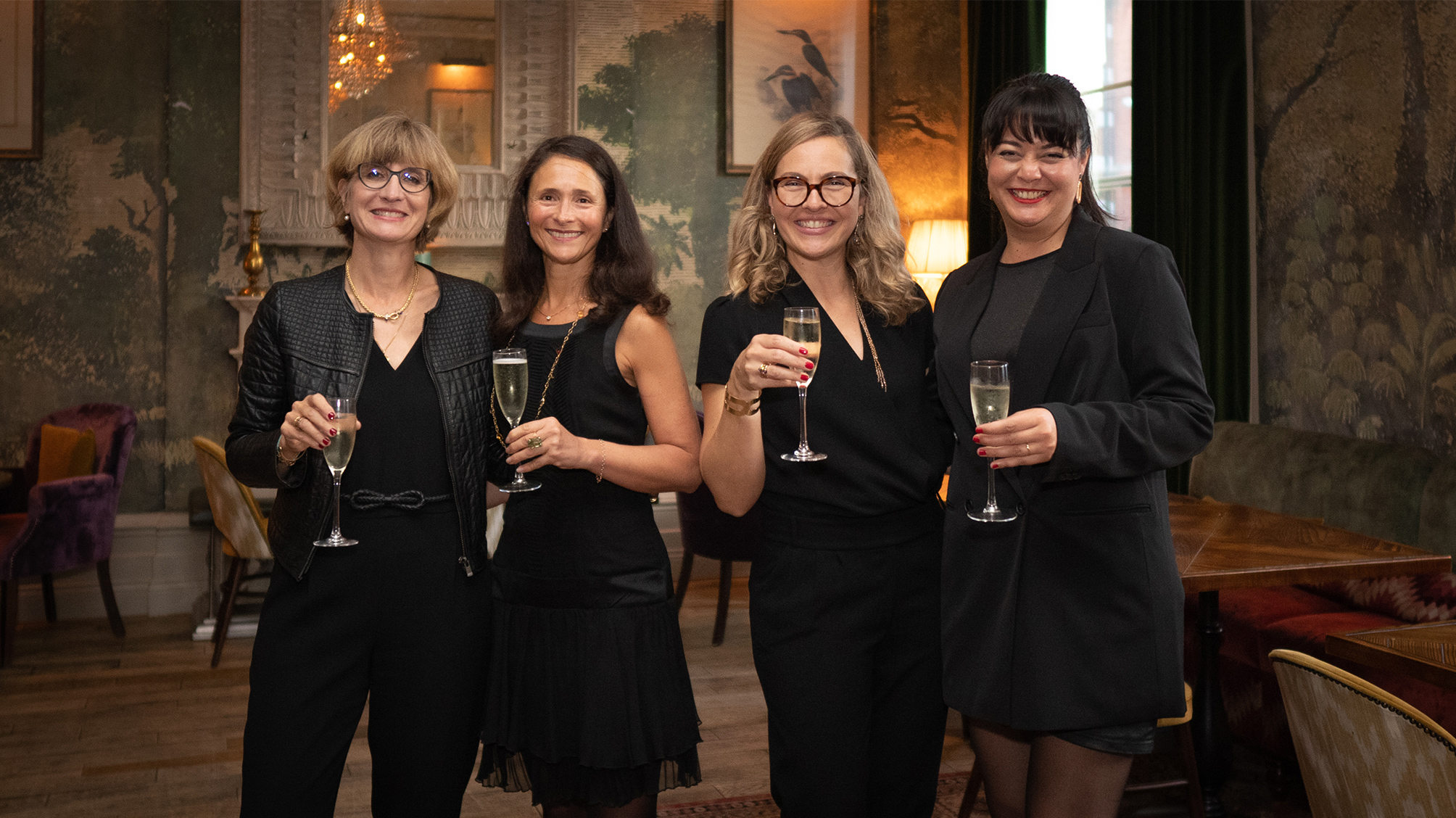 Visual aid: Four women posing at an event in a posh venue in London