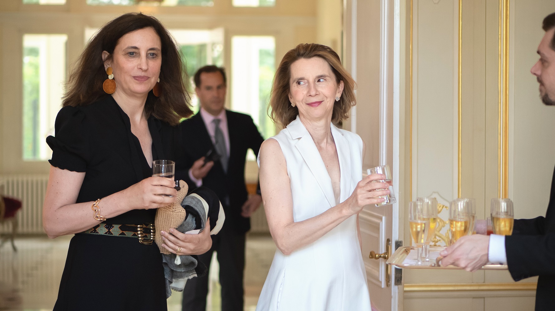 Visual aid: Two women getting soft drinks at an Event at the French Embassy in London