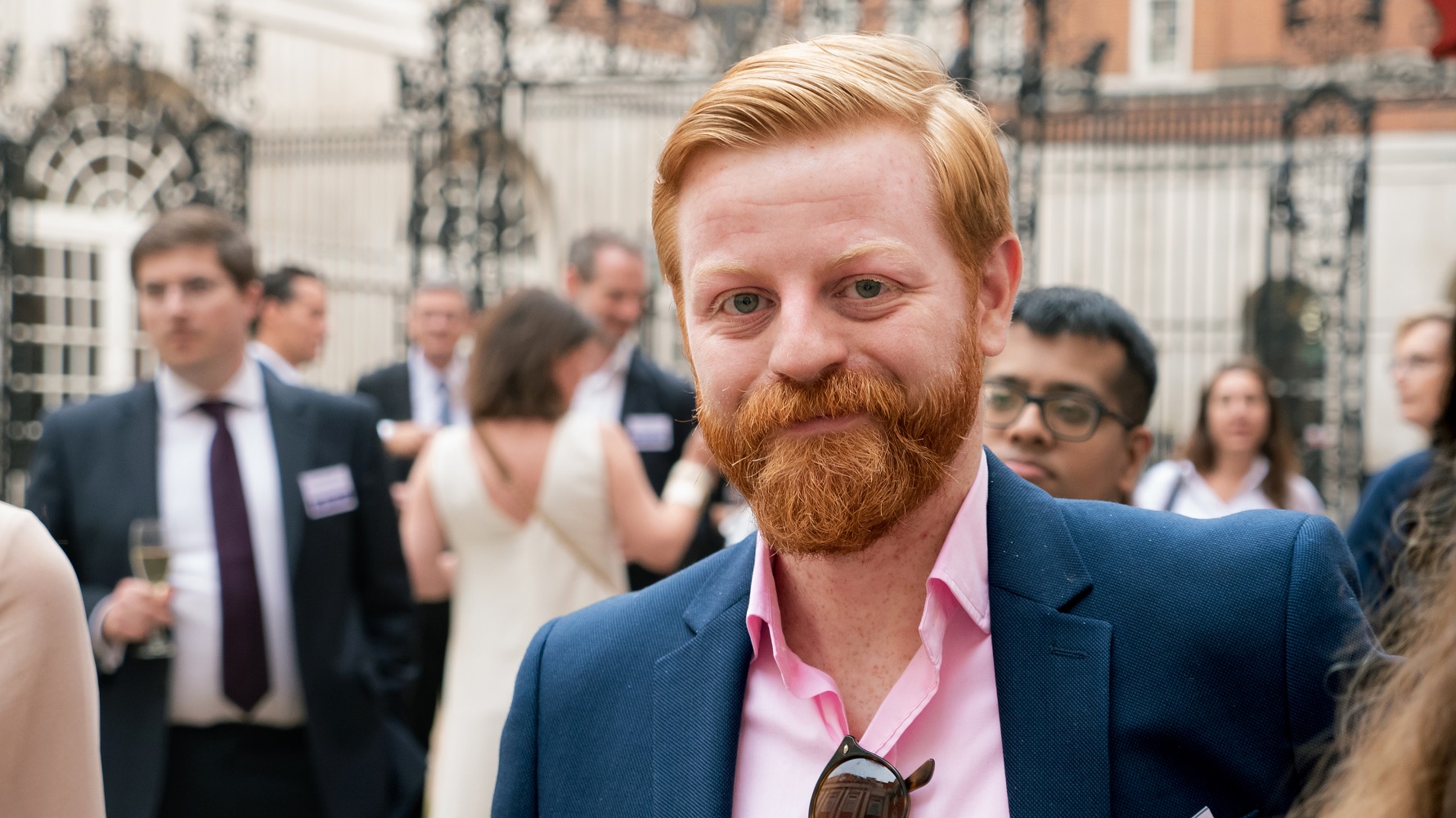Visual aid: Man smiling for the photographer at a summer party in London